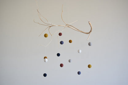 Móvil de rama con pelotitas de colores