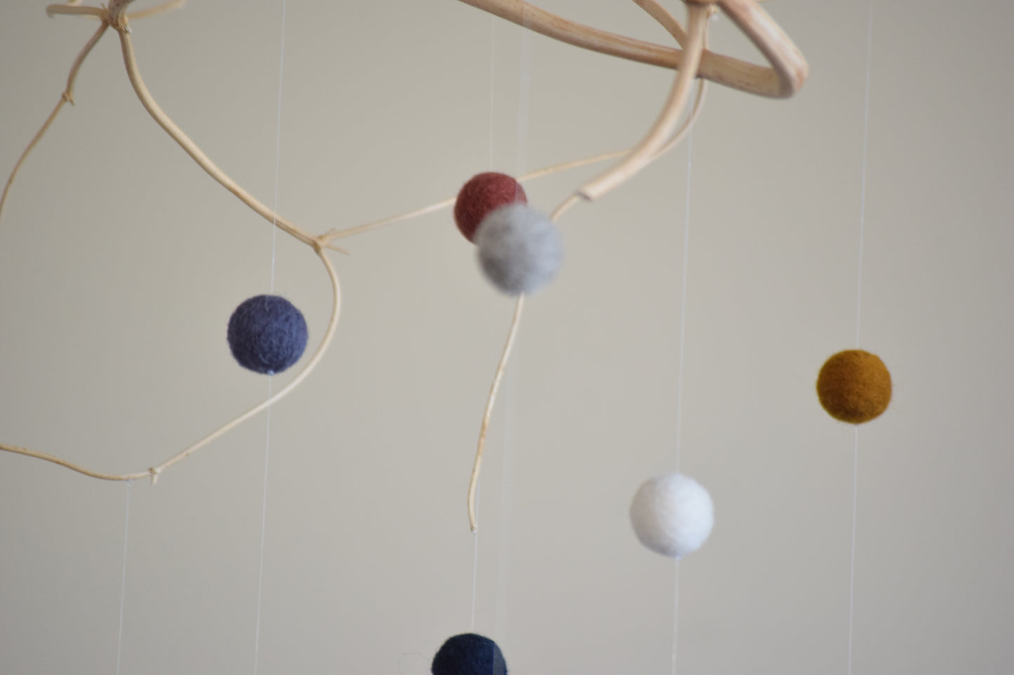 Móvil de rama con pelotitas de colores