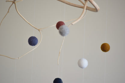 Móvil de rama con pelotitas de colores