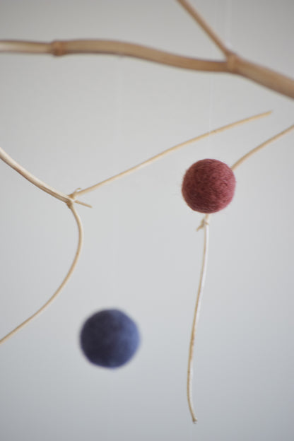 Móvil de rama con pelotitas de colores