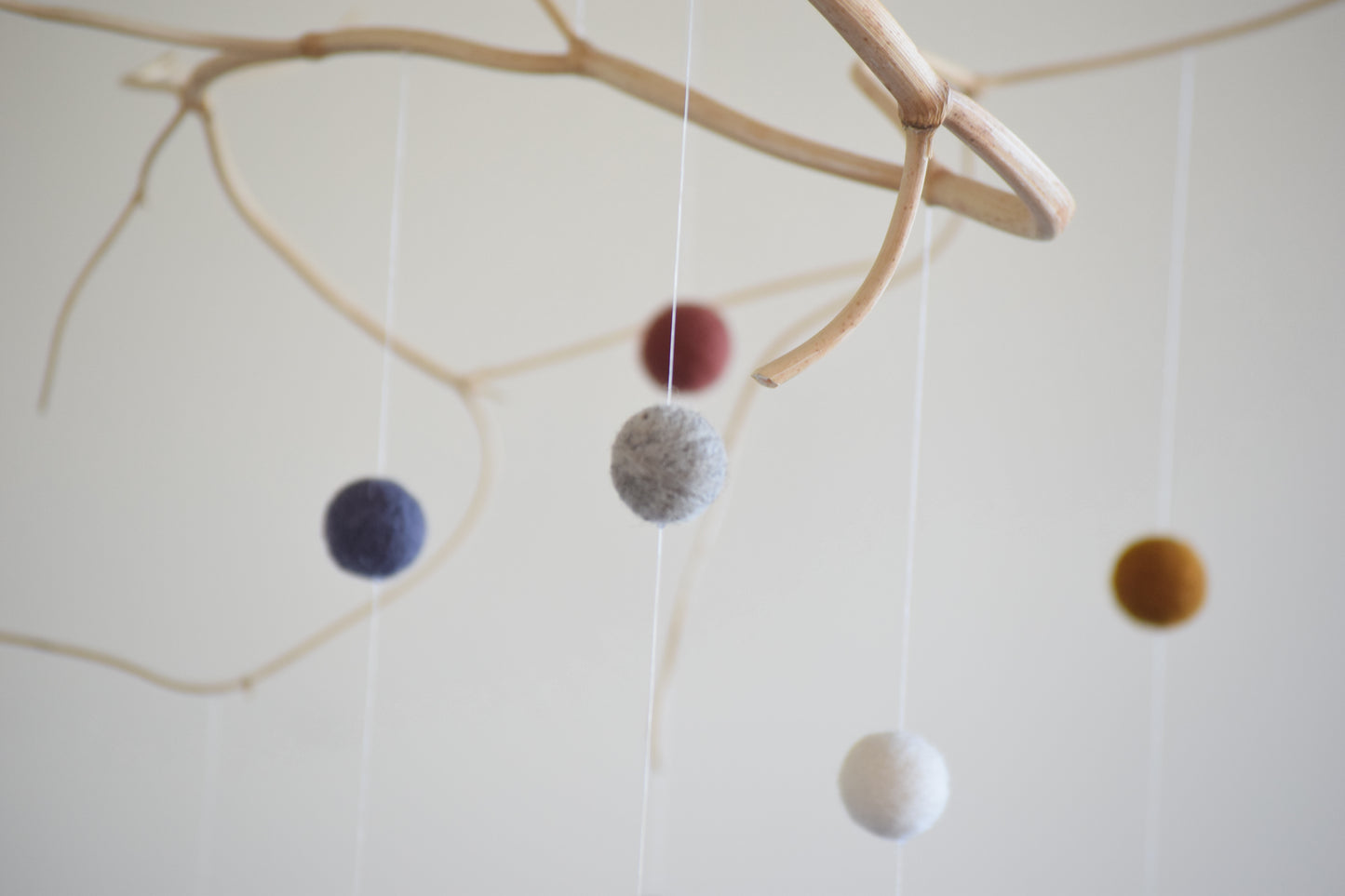 Móvil de rama con pelotitas de colores