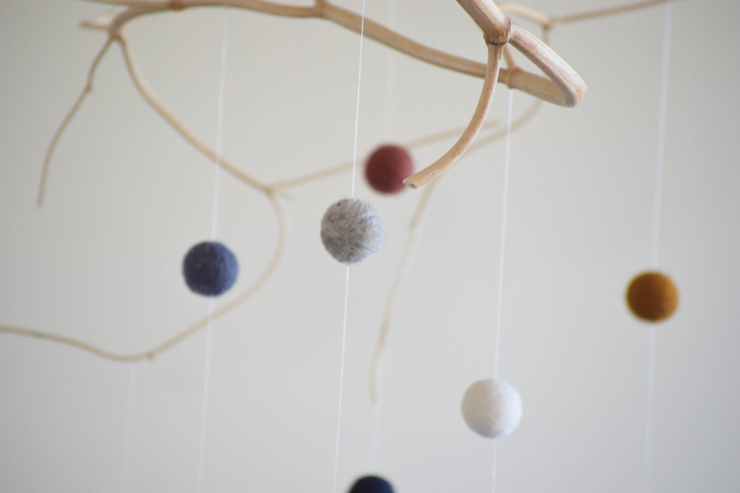 Móvil de rama con pelotitas de colores
