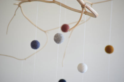 Móvil de rama con pelotitas de colores