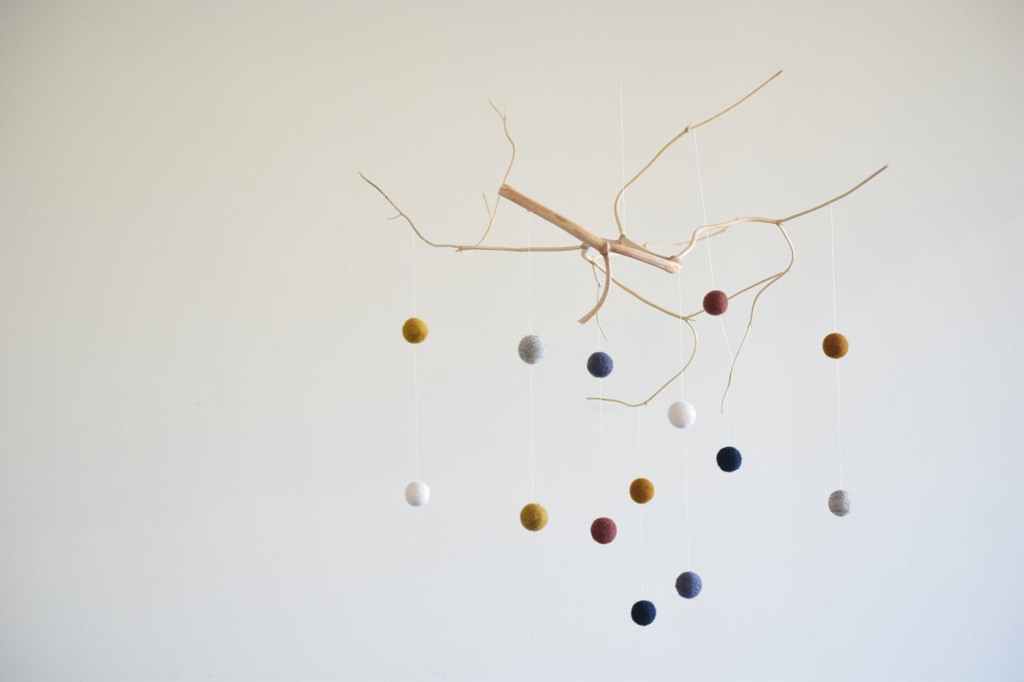 Móvil de rama con pelotitas de colores