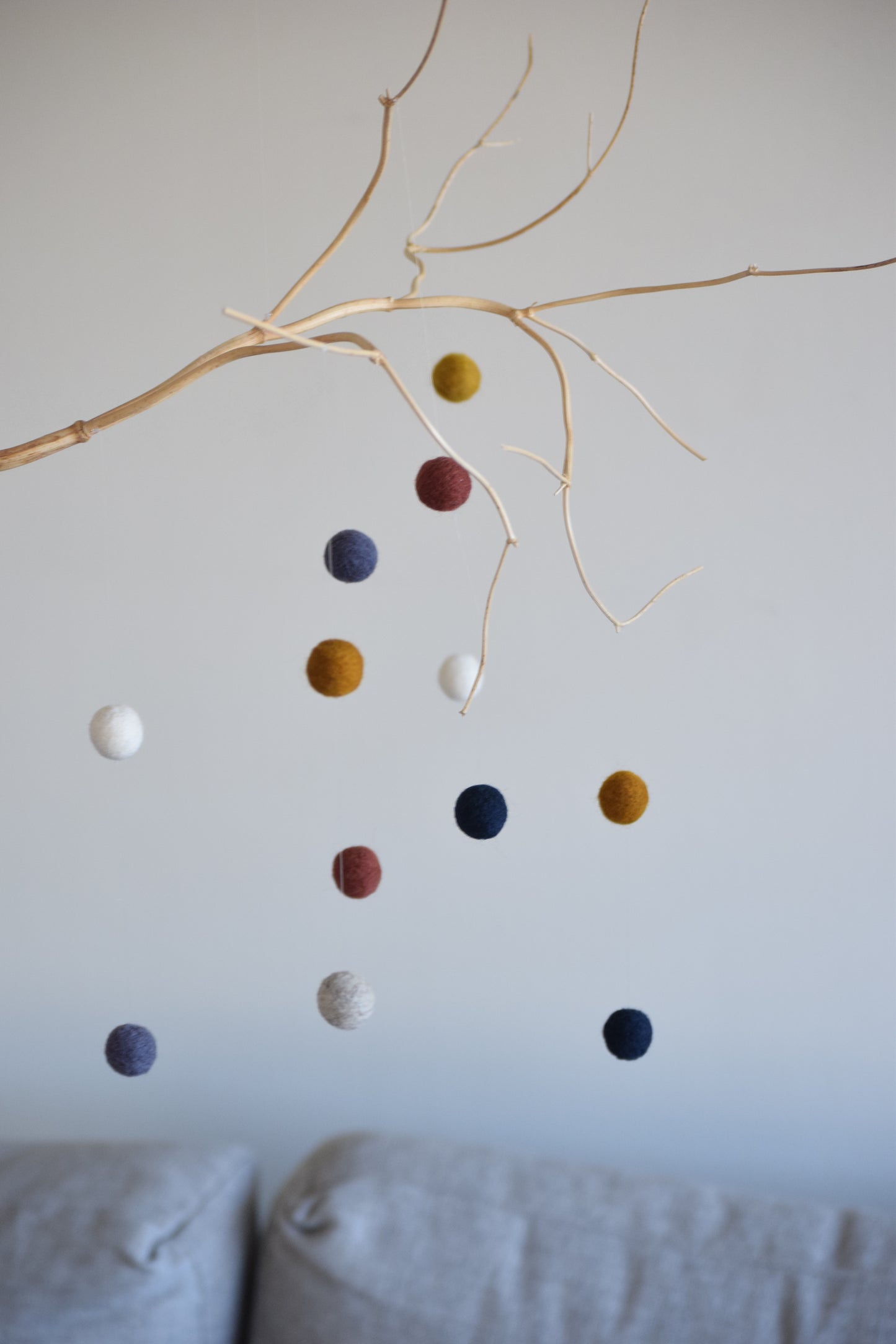 Móvil de rama con pelotitas de colores