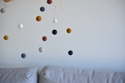 Móvil de rama con pelotitas de colores
